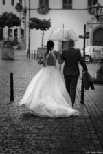 Brautpaar auf der Flucht vor dem Regen Fotografie Bildbearbeitung Daniel Kirsten Portrait Pirna Hochzeit Regen Schwarzweiß