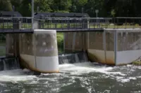 Staustufe am Nordumfluter.  Aufgenommen bei einem weiteren Urlaub im Spreewald mit dem zweiten Domiplan am APS-C-Sensor, f/2.8.  Unterhalb der Mitte hat sich, trotz Offenblende, ein markanter 6-zackiger Stern durch Lichtbeugung an den Blendenlamellen  gebildet. Nordumfluter Staustufe Domiplan