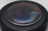 Die Frontlinse mit Fettschlieren. Links von der Mitte kann man die Luftblase erkennen. MC Sonnar 3.5/135
